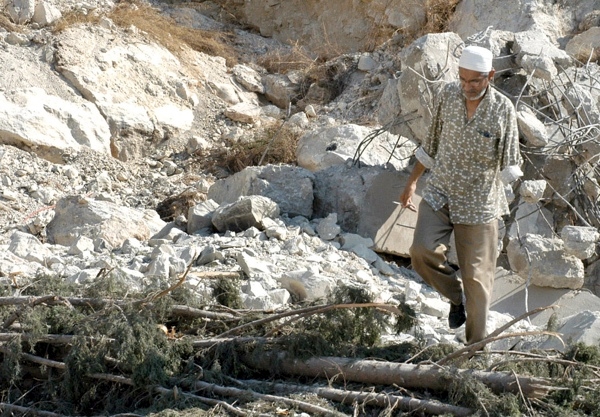 15 August 2006, Lebanon, Sidon, Palestinian Refugee Camp, Ain Al-Heweh. 2006 Lebanon War. Unidentified man, walks on destroyed destoyed buildings. 
