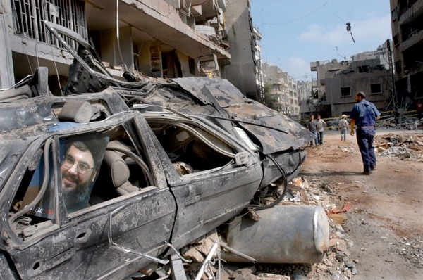 17 August 2006, Lebanon, Beirut, Dahia. 2006 Lebanon War. Unidentified man walks in the destroyied area. Lebanene people in order to keep their moral high, after Israeli forces bombing during the war , they placed photos of Sheikh Sayyed Hassan Nasrallah , leader of the Lebanese Hezbollah.