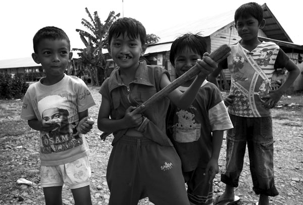 A gang of youth show their bravery by playing soldiers in an internal displacement camp in Banda Aceh, Indonesia.  Though reconstruction is evident everywhere in and around Banda Aceh, many are still living in camps after the devastating tsunami.  It is reported that levels of corruption are high as some families have secured 2-4 homes while others remain homeless.  February 2007.