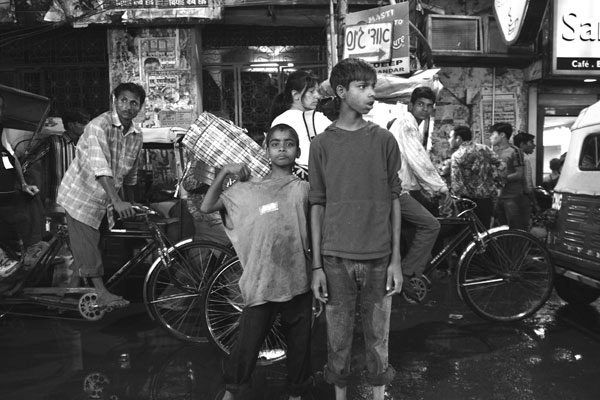Boys playing and posing for the camera in Par Ganj, Delhi, India.  Though India is now surging economically hundreds of thousands of poor and uneducated make their living by begging from tourists.  One of the most popular streets in Delhi for street kids and touts to work is Par Ganj.  March 2006.