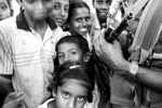 Children play around Sri Lankan army guards while waiting to be transferred to a new internally displacement camp one month after the tsunami in Batticaloa, Sri Lanka. This area is Tamil Tiger controlled and received very little of aid promised by the donors or government. February 2005. Children play around Sri Lankan army guards while waiting to be transferred to a new internally displacement camp one month after the tsunami in Batticaloa, Sri Lanka. This area is Tamil Tiger controlled and received very little of aid promised by the donors or government. February 2005.
