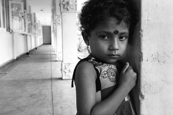 A young girl in a displacement camp in Batticaloa, Sri Lanka.  One month after the tsunami took her family, she could neither speak nor play, rather she spent her time staring out to the road waiting.  March 2005.